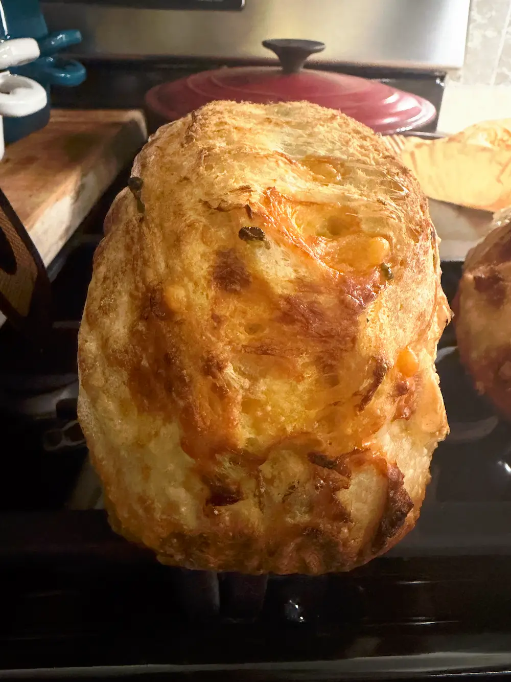 A jalapeño cheddar sourdough loaf cooling on the stovetop